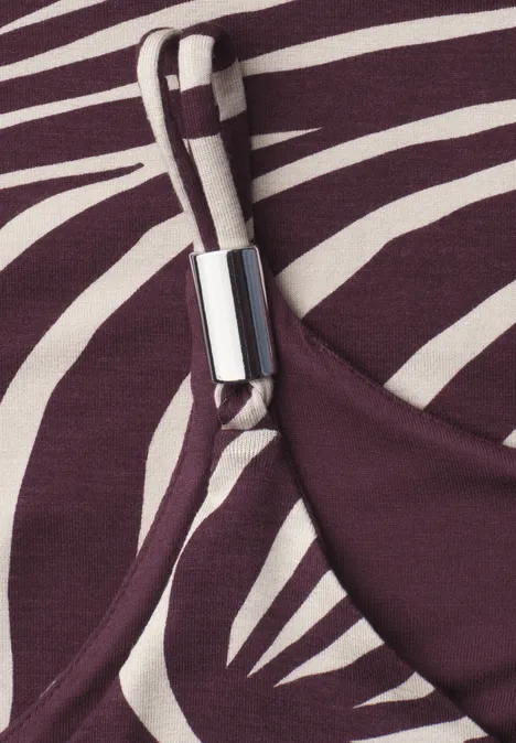 Gros plan sur une bretelle violet-blanc à motif zébré avec un fermoir métallique argenté