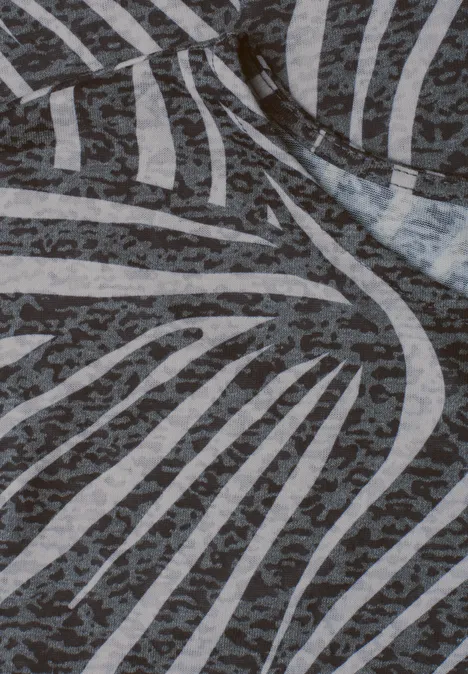 Nahe Ansicht eines Stoffes mit abstraktem Zebrastreifenmuster in Grau- und Weißtönen.