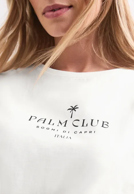 Koszulka na ramiączkach z napisem off white Zbliżenie białej koszulki z czarnym napisem „Palm Club Sorrento, Capri Italia” i ikoną palmy.