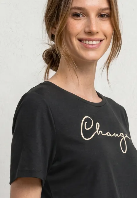 Portrait einer Frau mit schwarzem T-Shirt vor hellem Hintergrund.