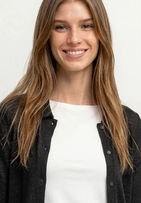 Leichte Langam Jacke in Leinen-Optik Black Eine Person mit langen braunen Haaren, weißem T-Shirt und schwarzer Strickjacke vor hellem Hintergrund.