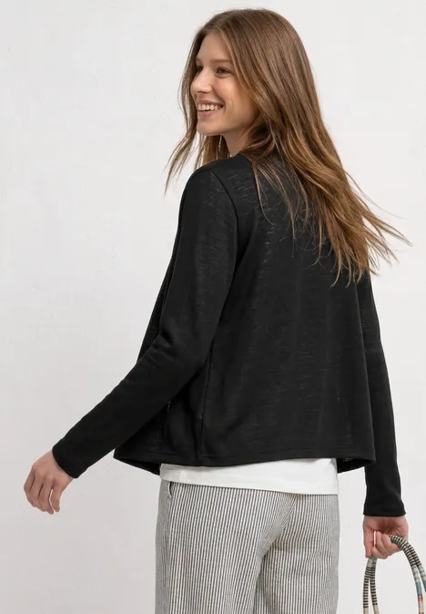Leichte Langam Jacke in Leinen-Optik Black Frau von hinten in schwarzer Strickjacke, weißem Shirt und grauen Hosen, hält Handtasche.