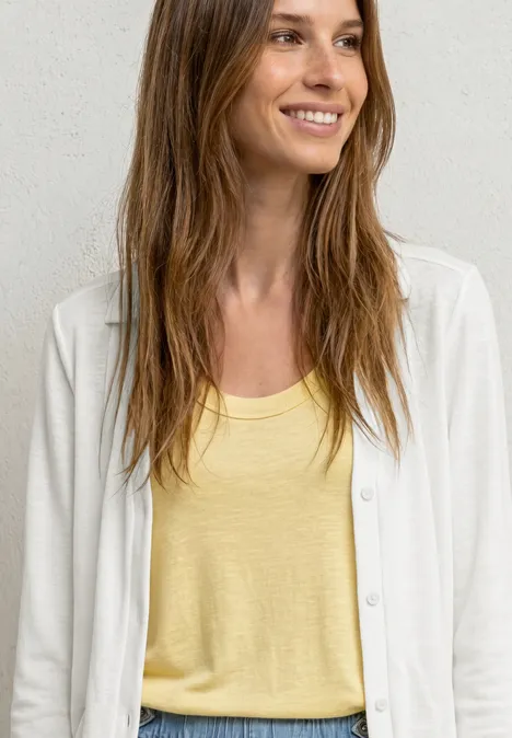 Leichte Langam Jacke in Leinen-Optik off white Frau mit langen Haaren trägt ein gelbes Top und eine weiße Strickjacke vor hellem Hintergrund.