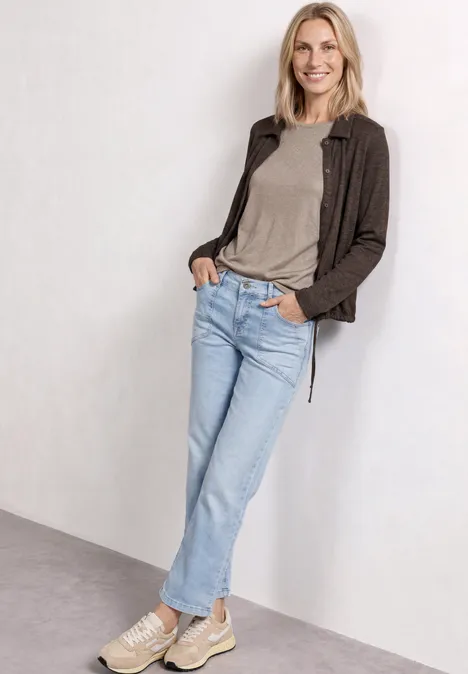 Leichte Langam Jacke in Leinen-Optik espresso brown Frau posiert in lässiger Kleidung: graues Shirt, braune Jacke, blaue Jeans und weiße Sneaker.