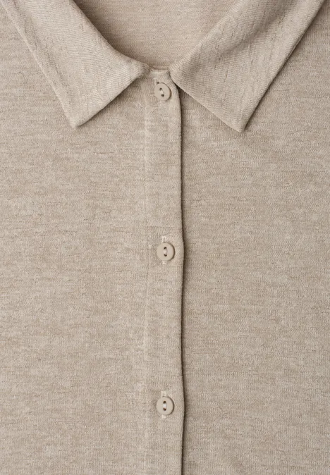 Nahaufnahme eines beigen Strickcardigans mit Hemdkragen und Knopfleiste.