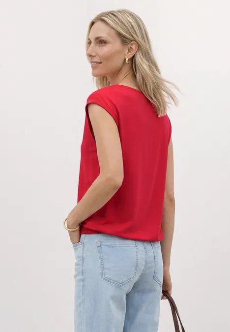 Dropped Shoulder Shirt mit U-Boot-Ausschnitt salsa red Frau von hinten mit rotem Top, hellen Jeans und Handtasche.