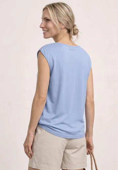 Basic Shirt mit U-Boot-Ausschnitt cashmere blue Frau von hinten in hellblauem ärmellosem Oberteil und beigen Shorts, sie hält eine geflochtene Tasche.