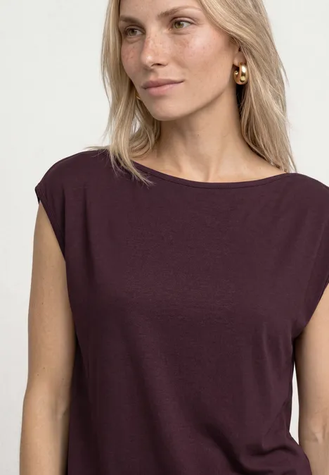 Basic Shirt mit U-Boot-Ausschnitt rustic rouge Blonde Frau in einem dunkelroten Top vor weißem Hintergrund.