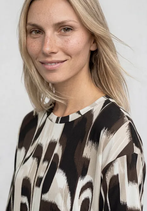 T-Shirt mit Rundhals und Tunnelzug espresso brown Frau trägt Bluse mit abstraktem braun-weißem Muster vor neutralem Hintergrund.