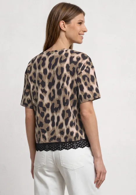 Vrouw van achteren in witte broek en kort luipaardprintshirt met kanten rand.