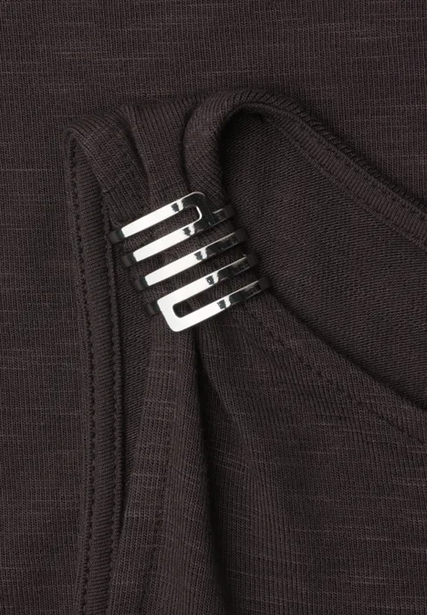 Schwarzes Tanktop mit silbernen Metallbeschlägen am Träger.