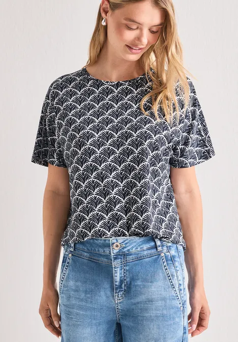 Femme en T-shirt bleu foncé à motif blanc et jean bleu