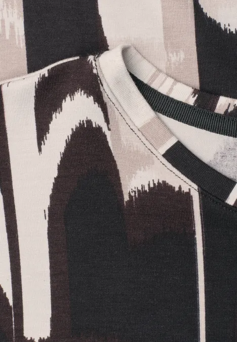 Close-up van twee T-shirts met abstract penseelstrekenpatroon in zwart, wit en beige