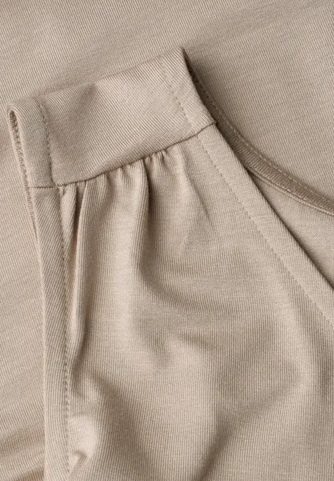 Top aus Jersey mit Elastiksaum sepia sand Detailansicht eines beigen Kleidungsstücks mit Tasche und feiner Stoffstruktur.
