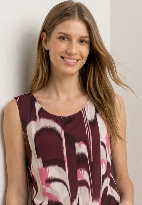 Vrouw met mouwloos topje met abstract patroon.
