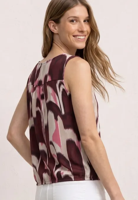 Een vrouw met lang haar draagt een mouwloos topje met abstract roze-wit-bruin patroon, rugaanzicht.