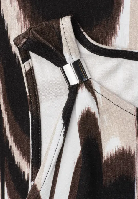 Nahaufnahme einer Handtasche mit abstraktem Braun-Weiß-Muster und silberner Schnalle
