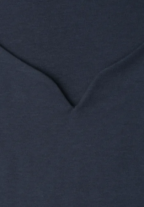 Detailaufnahme eines dunkelblauen Stoffes mit V-förmiger Naht.