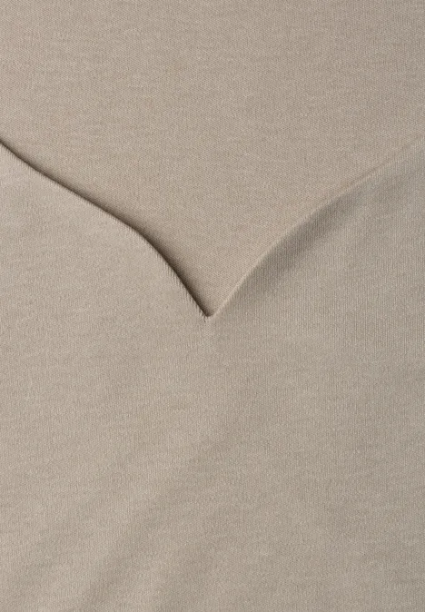 Beiger Pullover mit V-Ausschnitt aus weichem Strickstoff.
