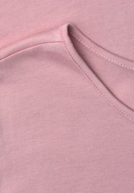 Nahaufnahme eines pinken T-Shirts mit Rundhalsausschnitt.