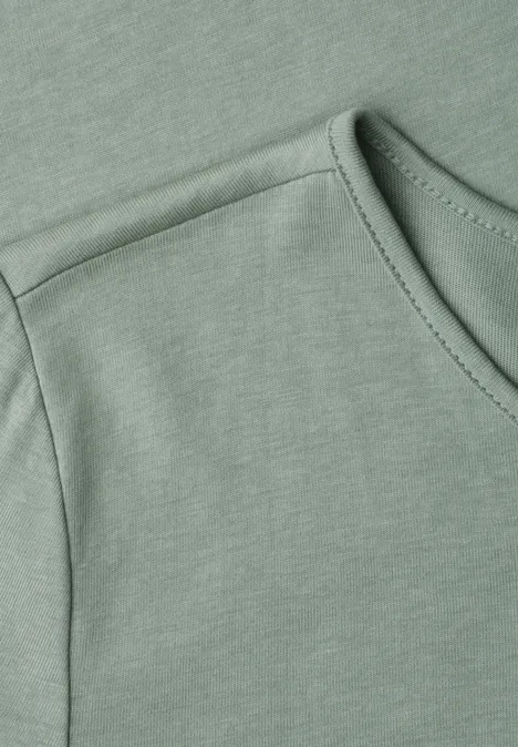 Salbeigrünes Shirt mit Rundhalsausschnitt und feiner Schulternaht.
