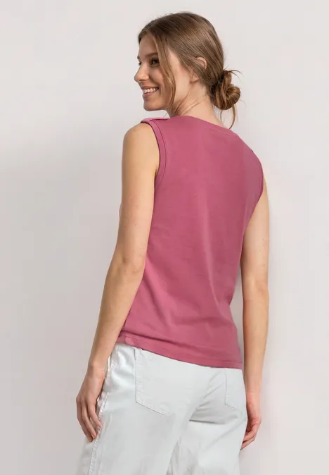 Haut à col V arrondi avec boutons aux épaules blush berry Frau von hinten, trägt ein ärmelloses magentafarbenes Top und helle Hosen, Haare im Dutt