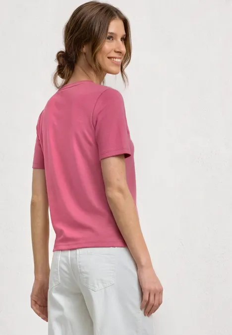 T-shirt avec poche poitrine décorative blush berry Vue arrière d’une femme en t-shirt rose et jean blanc sur fond neutre.