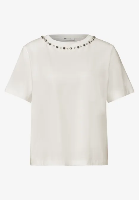 T-shirt blanc à manches courtes avec encolure ronde ornée de perles/clous discrets.