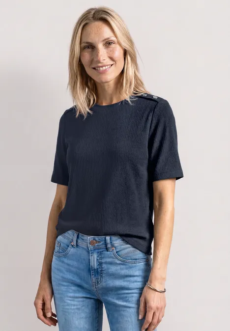 T-shirt à col rond avec boutons darkest blue Femme portant un t-shirt bleu marine à manches courtes et un jean, devant un fond neutre.