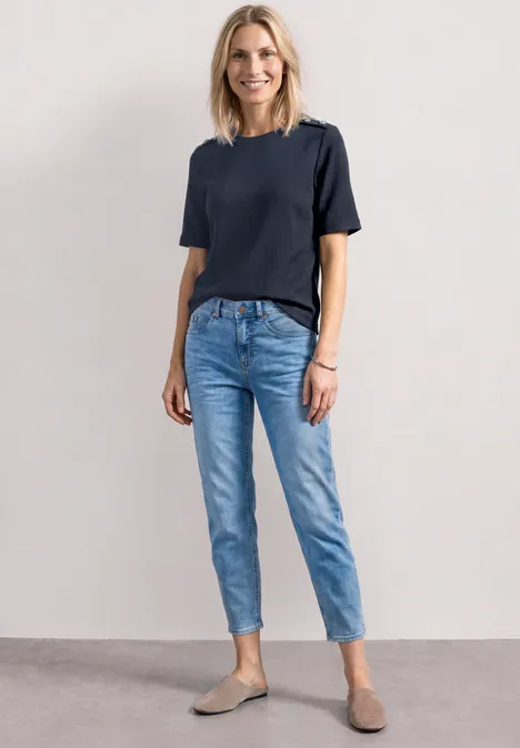 T-shirt à col rond avec boutons darkest blue Femme portant un t-shirt bleu marine, un jean clair et des mocassins gris sur fond neutre.