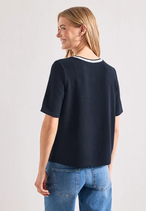 Shirt met gebreide look en ronde hals darkest blue Vrouw van achteren in een donkerblauw T-shirt met witte kraag en een blauwe spijkerbroek.