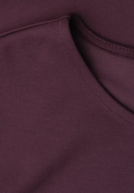 Shirt met ronde hals en volantdetail rustic rouge Close-up van de halslijn van een bordeauxrood T-shirt.