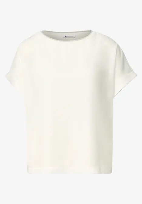 Top blanc féminin épuré en tissu léger, coupe droite, manches courtes et encolure ronde.