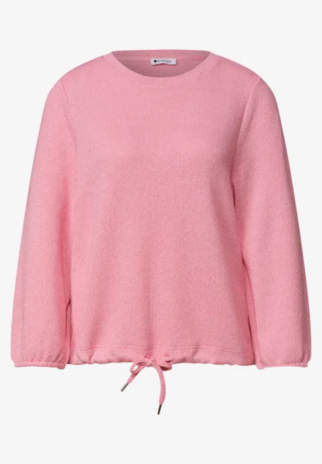 Ein locker geschnittener rosa Pullover mit Rundhalsausschnitt und Kordelzug am Saum.