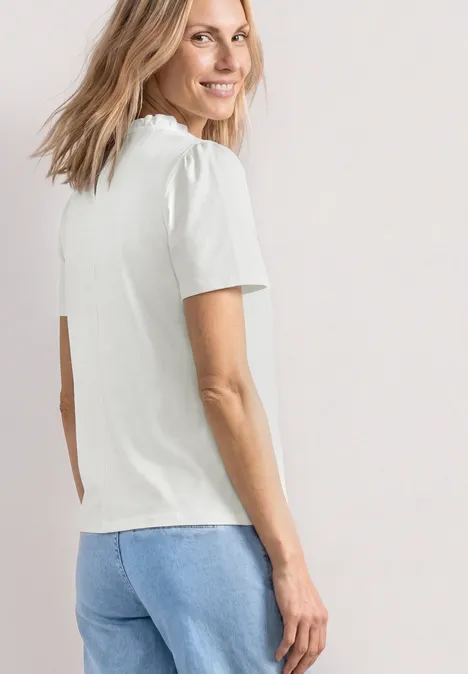 T-Shirt mit Rundhals und Rüschendetails off white Eine Frau von hinten mit weißem T-Shirt und blauen Jeans vor neutralem Hintergrund.