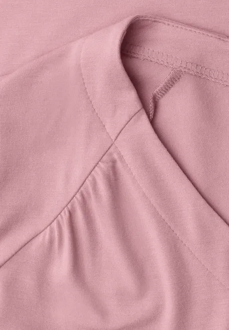 Nahaufnahme eines rosa T-Shirts mit feiner Naht am Ausschnitt.