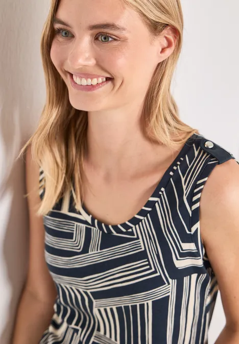 Haut à col en V et boutons décoratifs darkest blue Lächelnde Frau mit blondem Haar trägt ein ärmelloses Top mit schwarz-weißem geometrischem Muster.