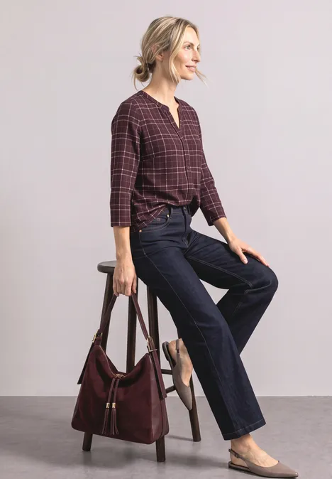 3/4-Arm Shirt mit Split Neck und Print rustic rouge Frau sitzt auf Hocker, trägt kariertes burgunderfarbenes Oberteil, weite Jeans, graue Ballerinas und Schultertasche.