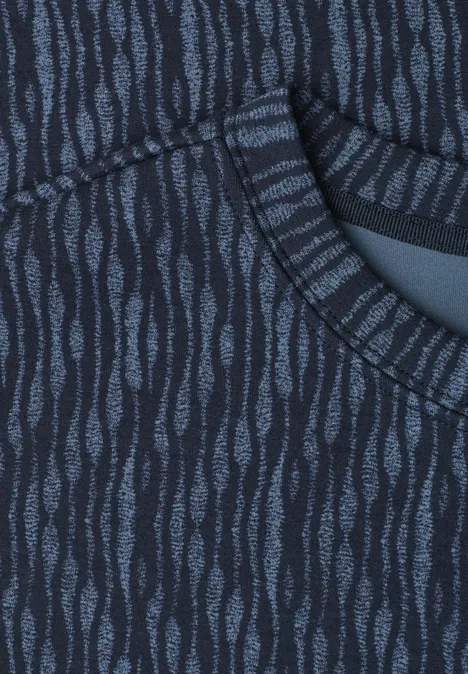 Nahaufnahme eines dunkelblauen Stoffes mit hellblauen, wellenförmigen Mustern und einer Tasche.