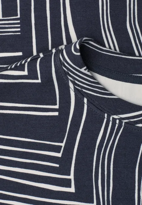 Nahaufnahme eines dunkelblauen Stoffes mit weißen, geometrischen Linienmustern und Halsausschnitt.