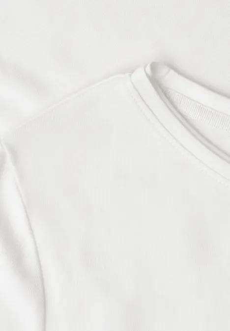 Nahaufnahme eines weißen T-Shirts mit Rundhalsausschnitt und feiner Baumwollstruktur.