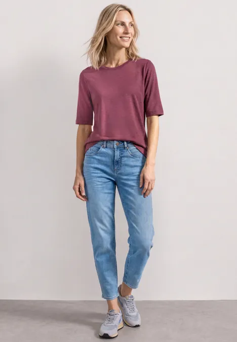 Basic T-Shirt mit Rundhals in Unifarbe dark clouded blush Eine junge Frau trägt ein rotes T-Shirt, blaue Jeans und graue Sneaker vor schlichter Wand.