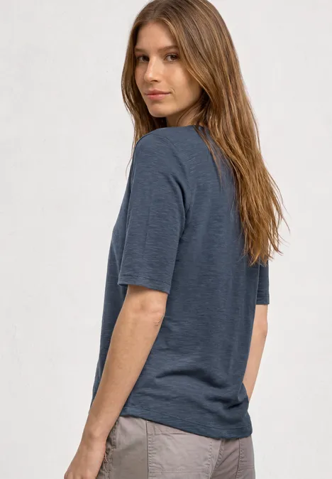 Basic Shirt met ronde hals in Unifarbe ashen blue Zijaanzicht van persoon met halflang haar, grijs T-shirt en lichte broek.