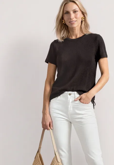 Basic T-Shirt im Strick-Look mit Rundhals black coffee Frau mit schwarzem T-Shirt, weißen Jeans und beiger Tasche.