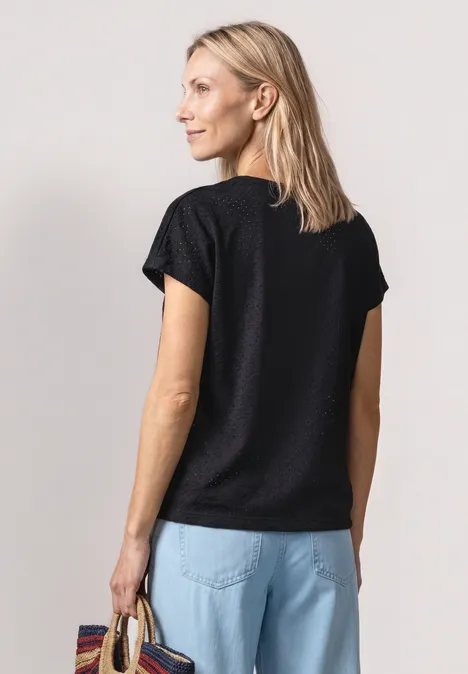 T-Shirt aus Spitze mit Rundhals Black Frau von hinten in schwarzem T-Shirt und hellblauen Jeans, stehend und Tasche in der Hand.