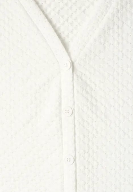 Top met V-hals en decoratieve knoopsluiting off white Witte, gestructureerde cardigan met knoopsluiting.
