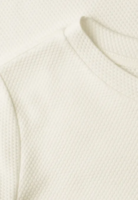 T-shirt à col rond et texturé off white Nahaufnahme eines weißen Shirts mit feiner Wabenstruktur im Stoff.