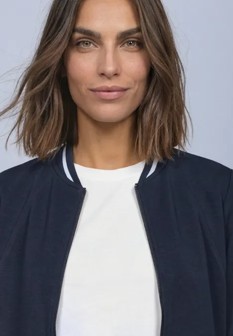 Langarm Jacke im Silk-Look mit Zipper darkest blue Eine Frau mit schulterlangen braunen Haaren trägt ein weißes Shirt und eine dunkle Jacke vor hellem Hintergrund.