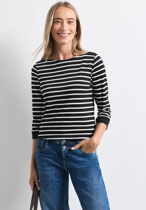 Shirt met 3/4-mouwen en een boothals Black Frau trägt gestreiftes Langarmshirt und Jeans, lächelt und hält seitlich eine Tasche.