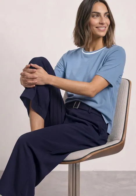 Shirt met ronde hals en contrasterende details northern blue Vrouw in blauwe broek en lichtblauw shirt zit ontspannen op stoel
